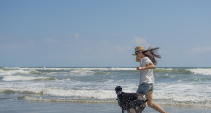 바다에서 달리는 도베르만과 여자.