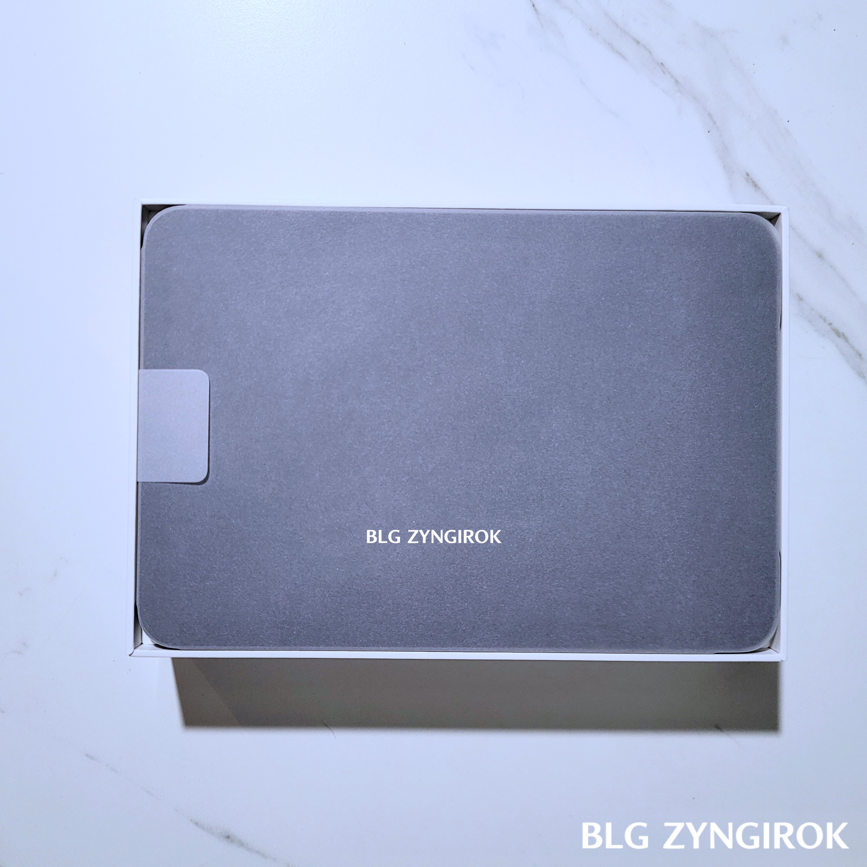 아이패드 미니가 상자안에 들어있는 모습이다. 아이패드는 종이에 싸여있다.