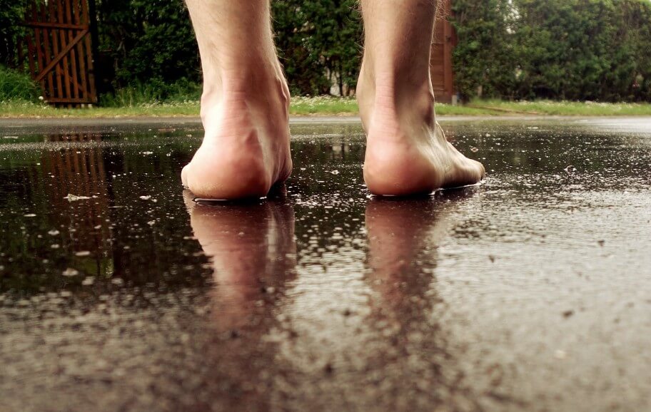 비오는 날 맨발로 거리를 걷고 있는 모습