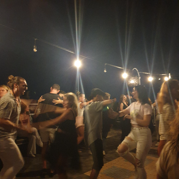 검은 하늘 줄에 달린 조명 아래서 춤을 추는 사람들