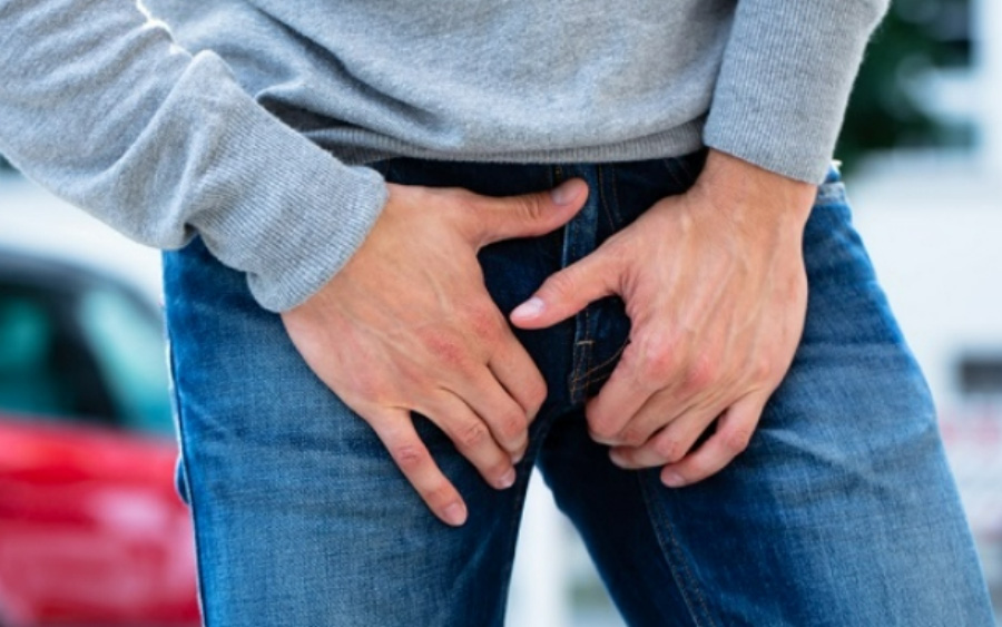 청바지를 입은 남성이 사타구니 부위에 가래톳이 발생이 되어 통증을 억제하기 위해 양쪽 손으로 통증 부위를 누르고 있는 것을 찍은 사진
