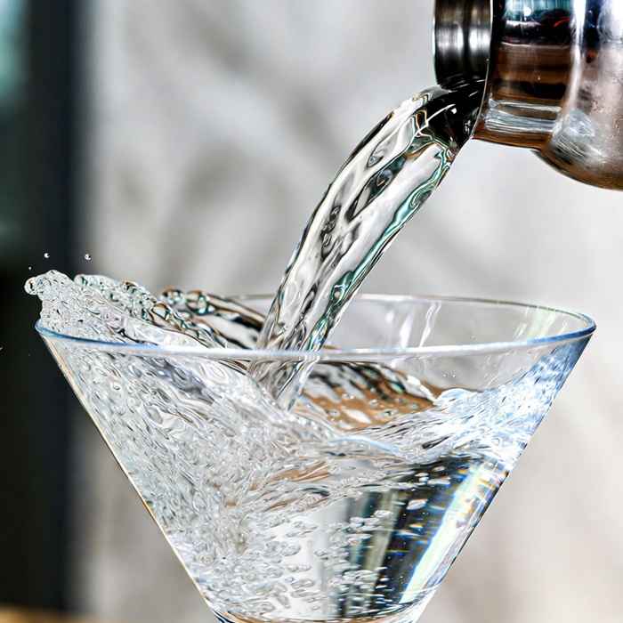 셰이커에서 잔으로 따르는 차가운 보드카 마티니 제조 과정