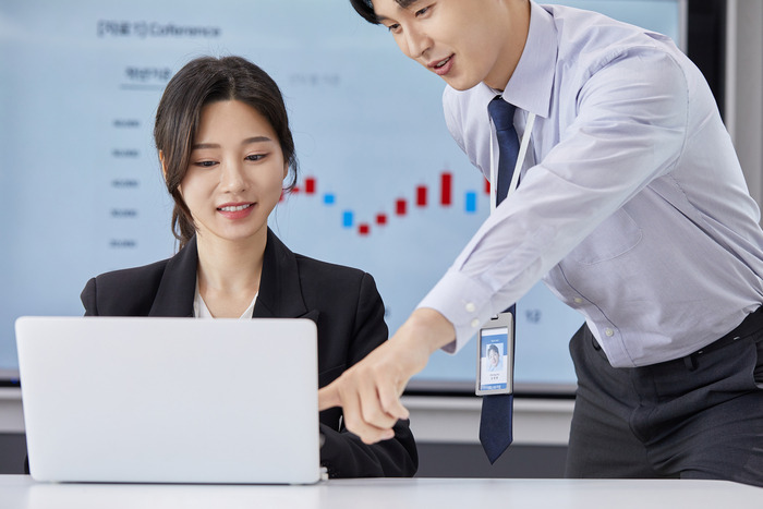 남자 여자가 노트북을 보는 사진