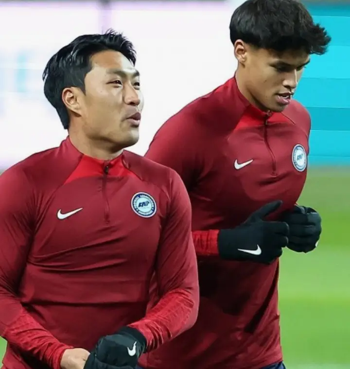 붉은 유니폼을 입고 축구장에서 연습하는 싱가포르 두 선수