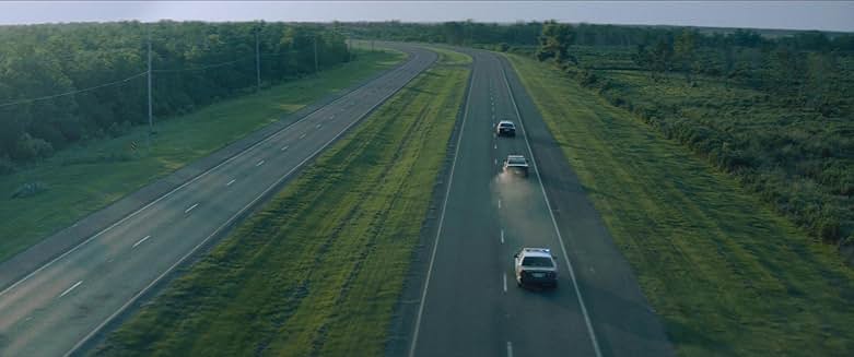 Rebel Ridge 영화 장면, 경찰 차량들이 고속도로에서 추격 중인 장면