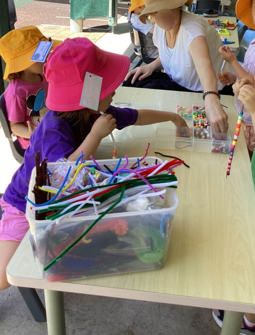 비즈로 팔찌를 만들고 있는 아이들