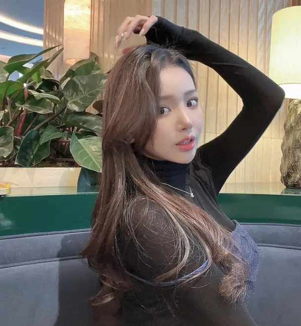 솔로지옥 3- 파란색 긴 소파위 검정색 긴팔 폴라티에 은색 목걸이를 하고 갈색 긴머리를 왼손으로 쓸어올리며 옆을 바라보고 앉아있는 김규리