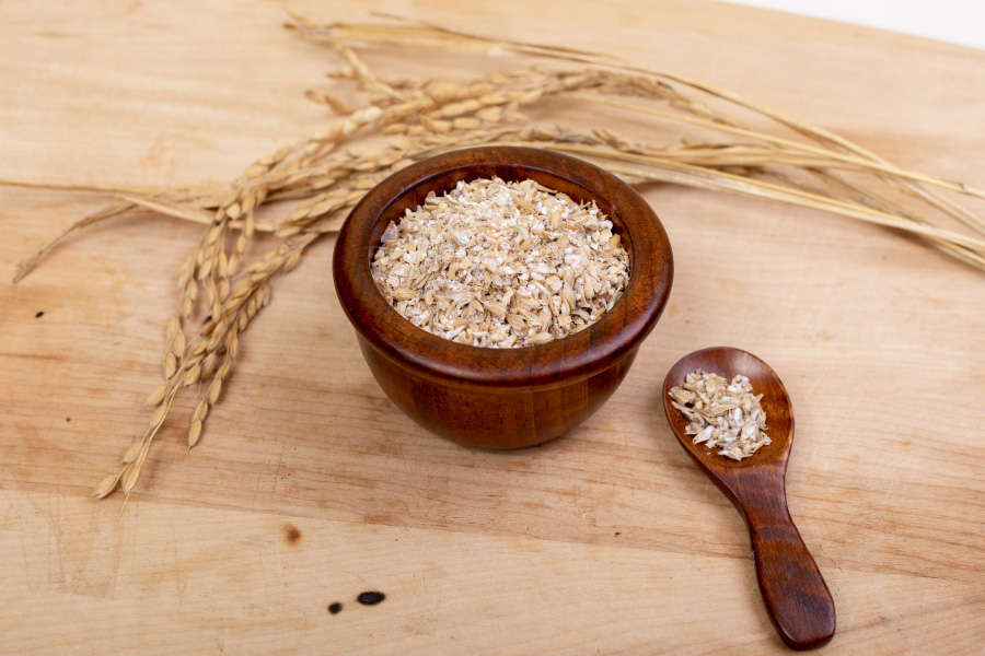 야생에서 채취를 한 보리쌀을 나무 바닥 위에 놓아두고 그 밑에는 갈색 나무 그릇과 숟가락에 보리 엿기름을 가득 담아두고 찍은 사진