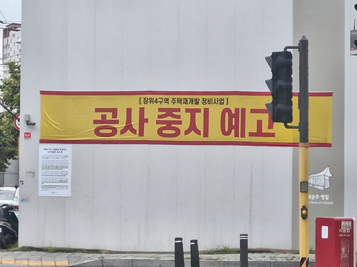 하얀휀스에-공사중지-현수막이-붙여져-있다