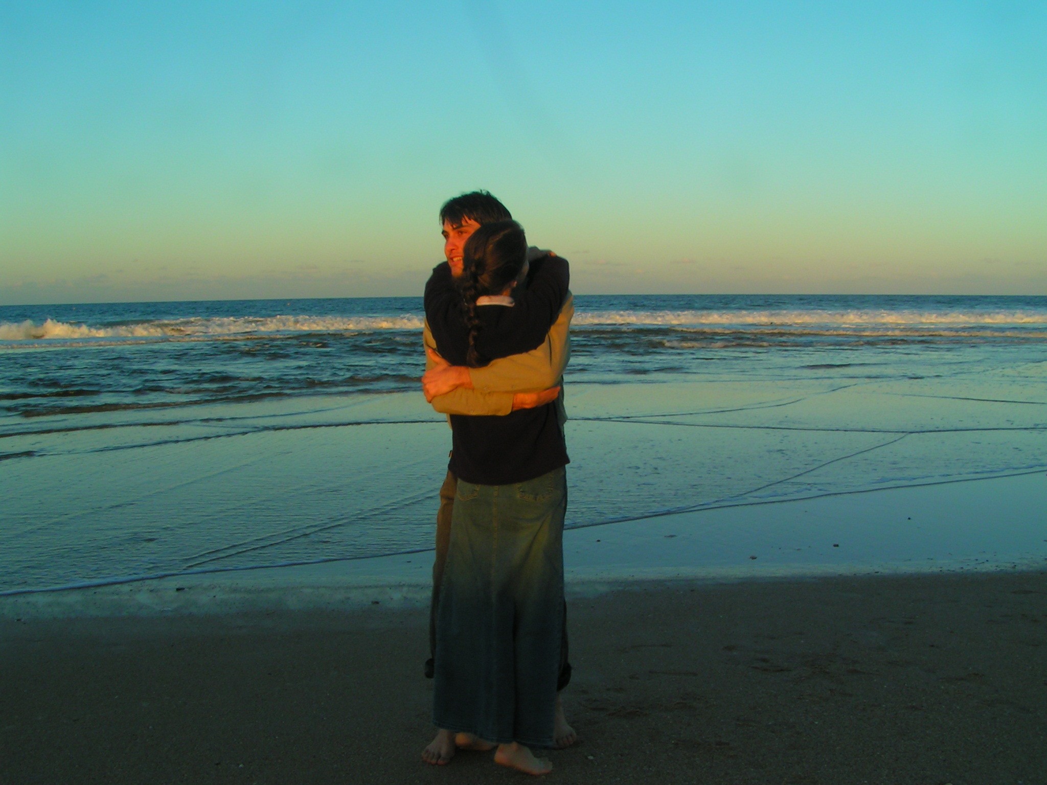 한쌍의 커플이 해변에서 껴안고 있는 사진