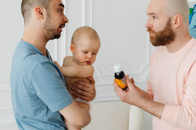 의사 선생님과 상담하는 아기를 앉고 있는 아빠