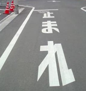 일본어로 '멈춰라'라고 도로에 표시되어 있다.