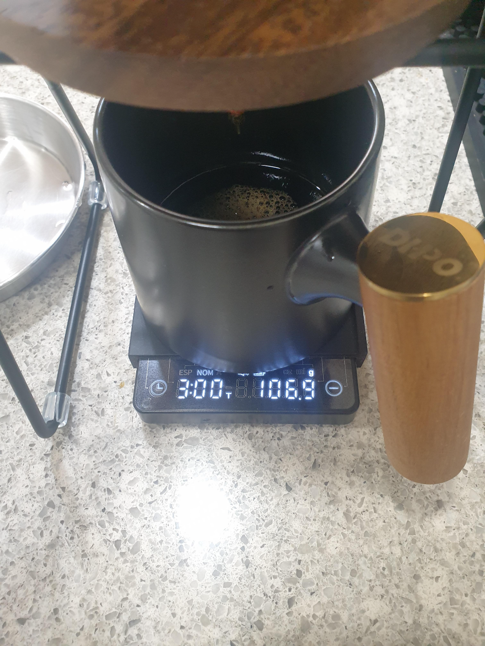 저울위에 컵이 올려져 있고 저울이 106g을 가르키고 있다.