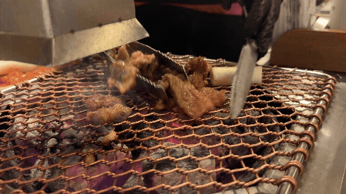 세광양대창 정자점 직원이 불판 위에서 마늘 소갈비살을 집게로 구워주는 장면 GIF, 불향이 피어오르는 모습