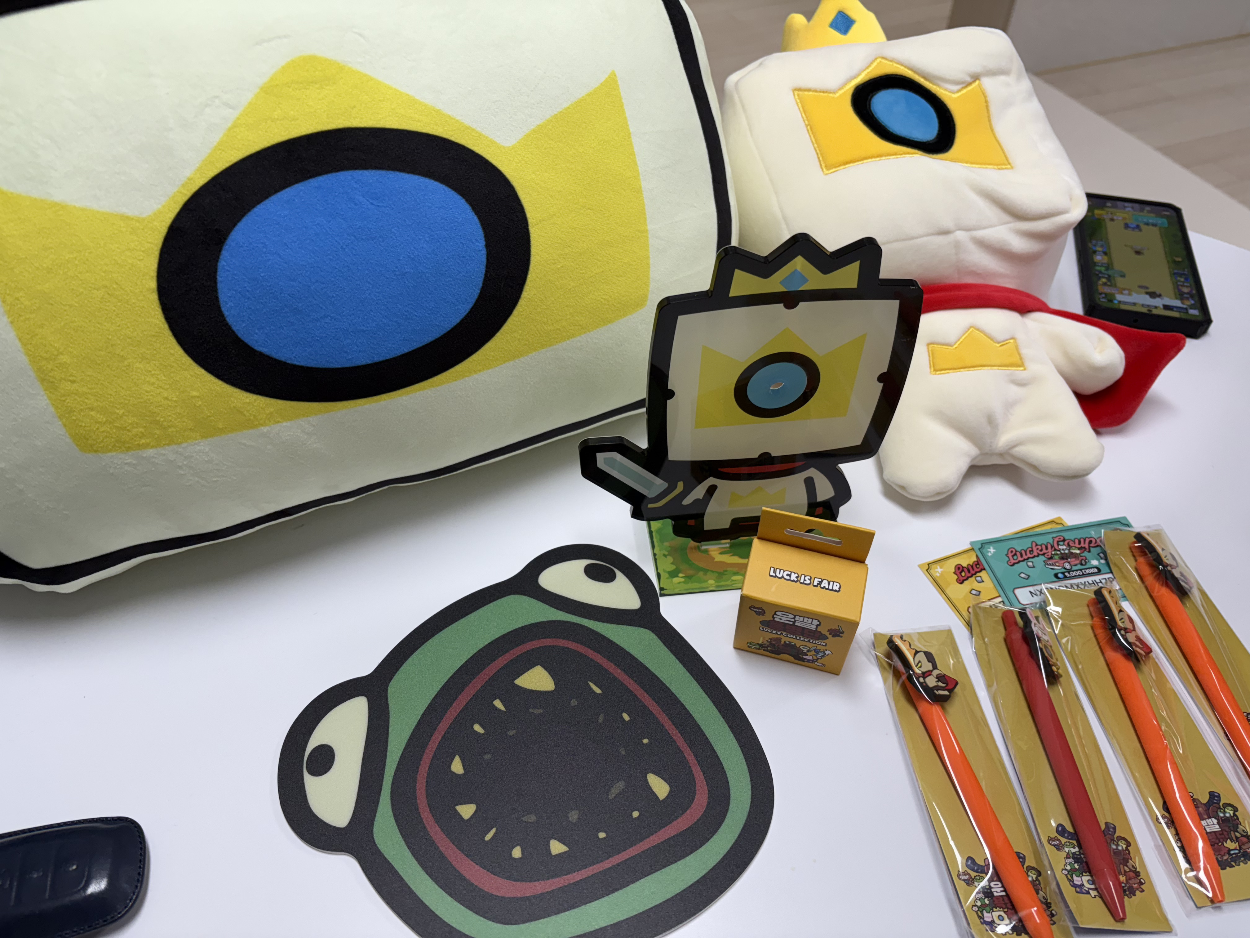 하얀-테이블-위에-빠란볼펜-주황볼펜-마우스패드-캐릭터-인형들