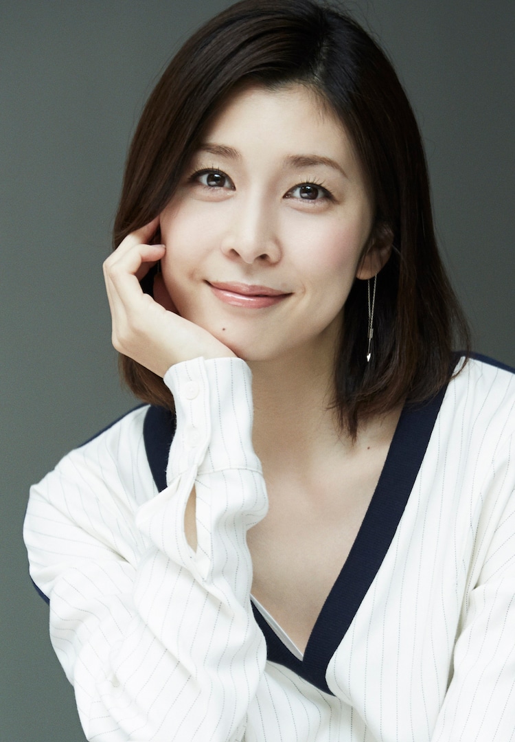 다케우치 유코, 한 손으로 턱을 바치며 따뜻하게 웃고 있다