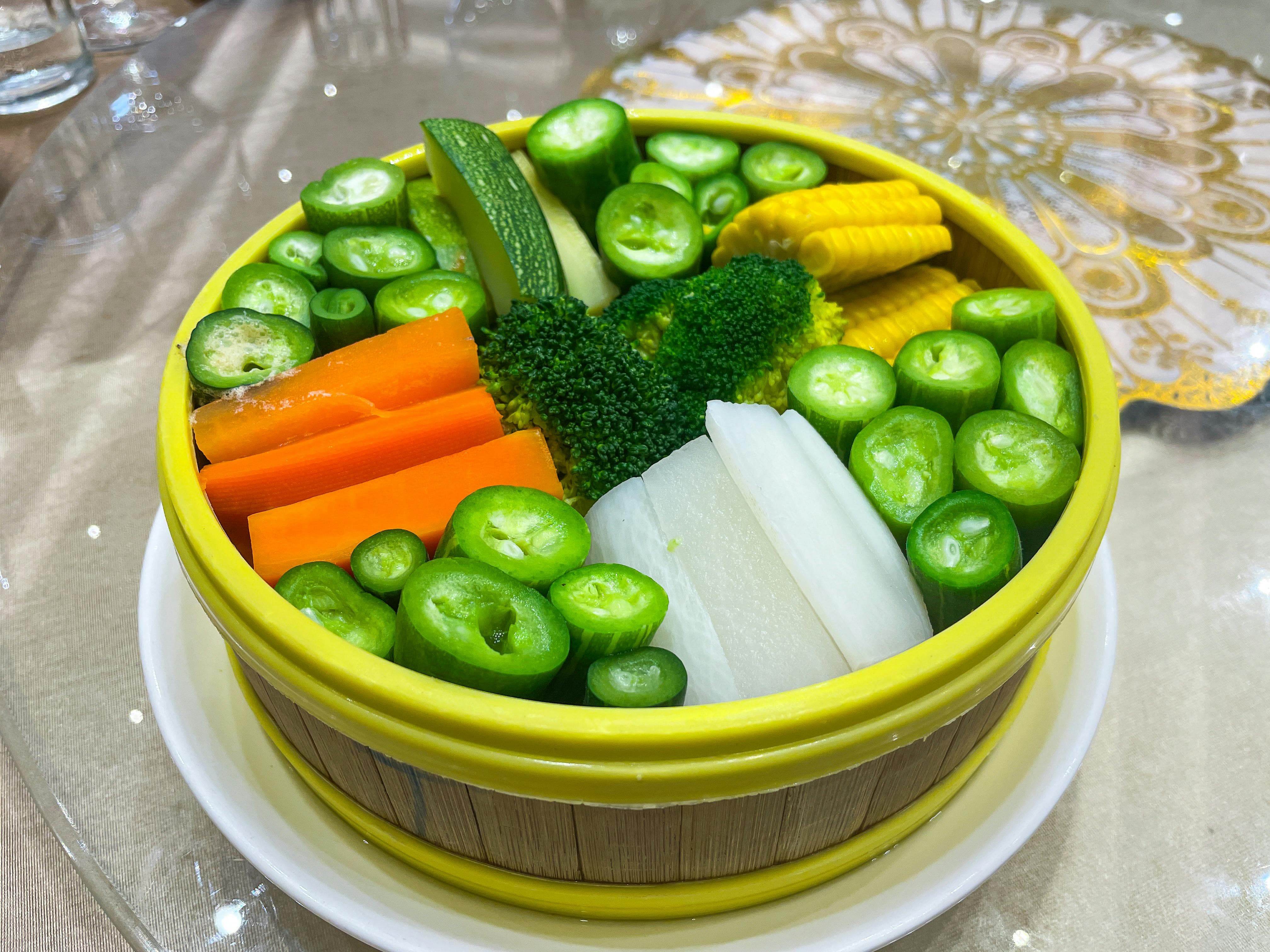 둥근접시안에 가지런히 놓인 당근, 오이, 옥수수, 브로콜리, 양파,애호박등 각종 야채들