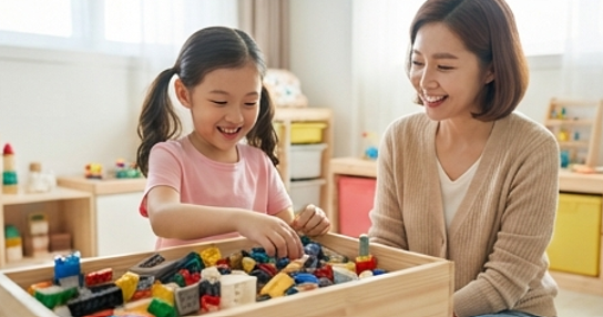 딸이 장난감을 상자에 넣으며 웃는 장면