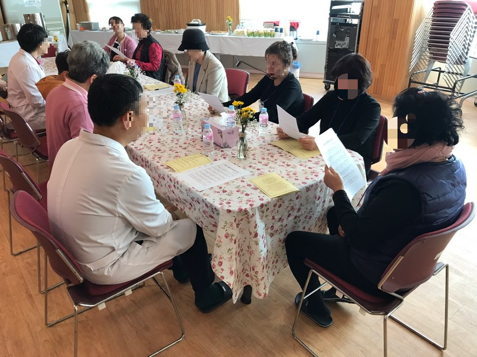 alt="사별가족과 의료진이 둘러앉아 추억을 나누며 위로를 전하는 징검다리모임 나눔시간"