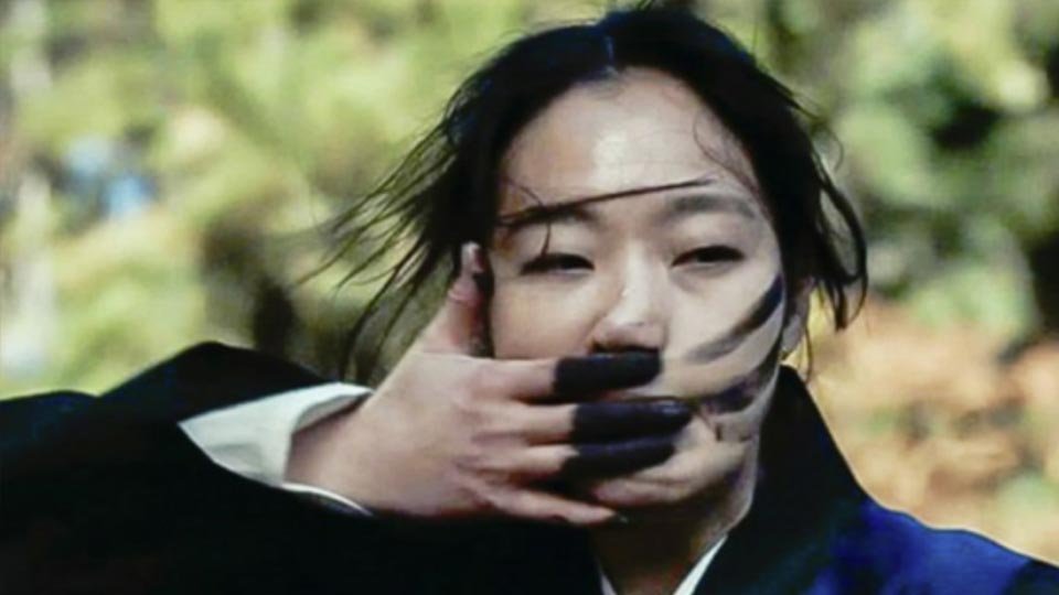 이화림이 굿하기전 얼굴에 숫을 바르고 있다.