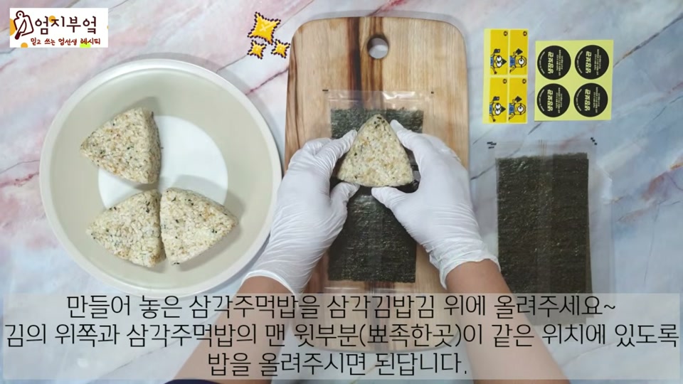 삼각 주먹밥을 김으로 감싸는 장면