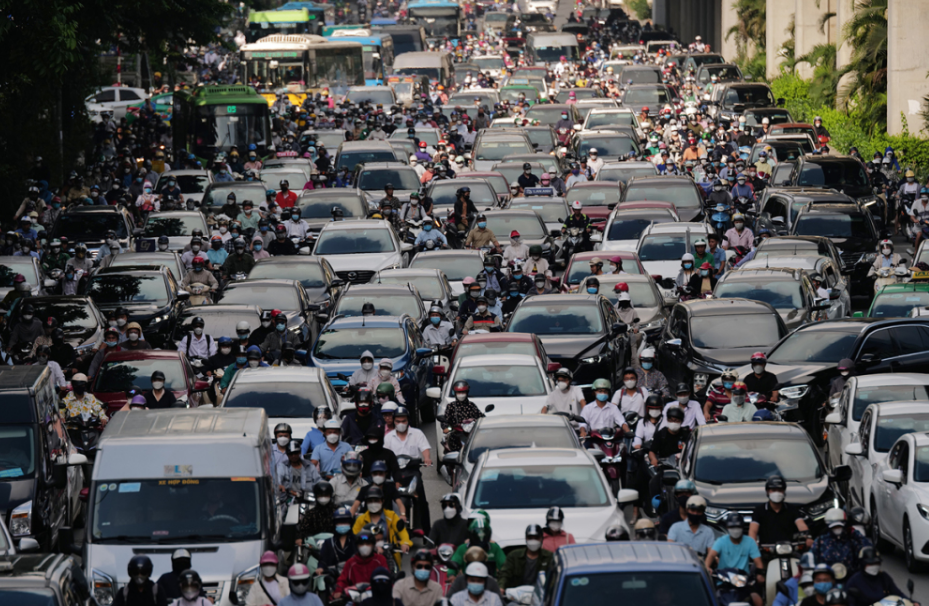 많은 오토바이와 자동차가 도로에 가득차 교통체증이 풀리길 기다리고 있습니다.