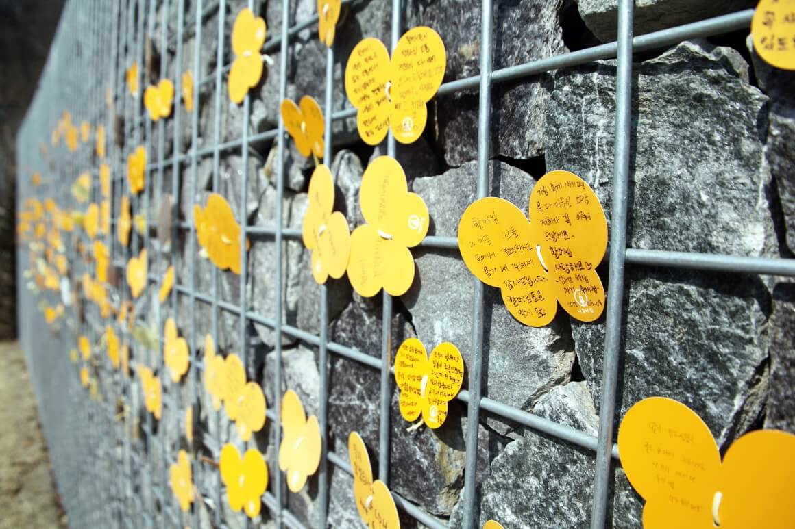 제2역사관 추모공원 뒤 담벼락 풍경. 방문객들이 직접 쓴 추모 메시지가 노란 나비처럼 빼곡하게 달려 있다.