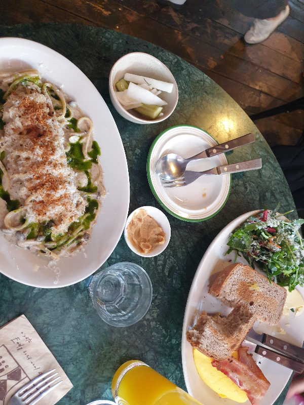 초록색 테이블 위에 왼쪽에는 파스타가 오른쪽에는 토스트가 보인다.