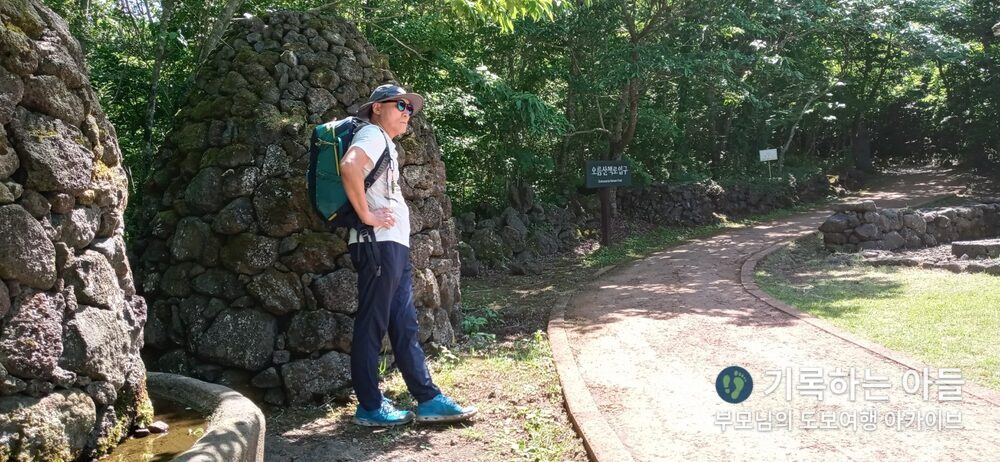 돌담 구조물 앞 아버지