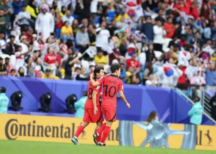 태국전- 그라운드에서 붉은유니폼을 입고 어깨동무하며 뛰는 선수2명