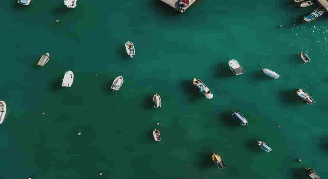 잔잔한 바다 위에 작은 배들이 흩어져 있는 항구 풍경이다. [ⓒpexels_Polina]