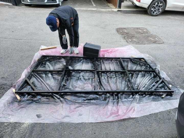 허리를-굽히고-나무문틀에-검정락카-뿌리기