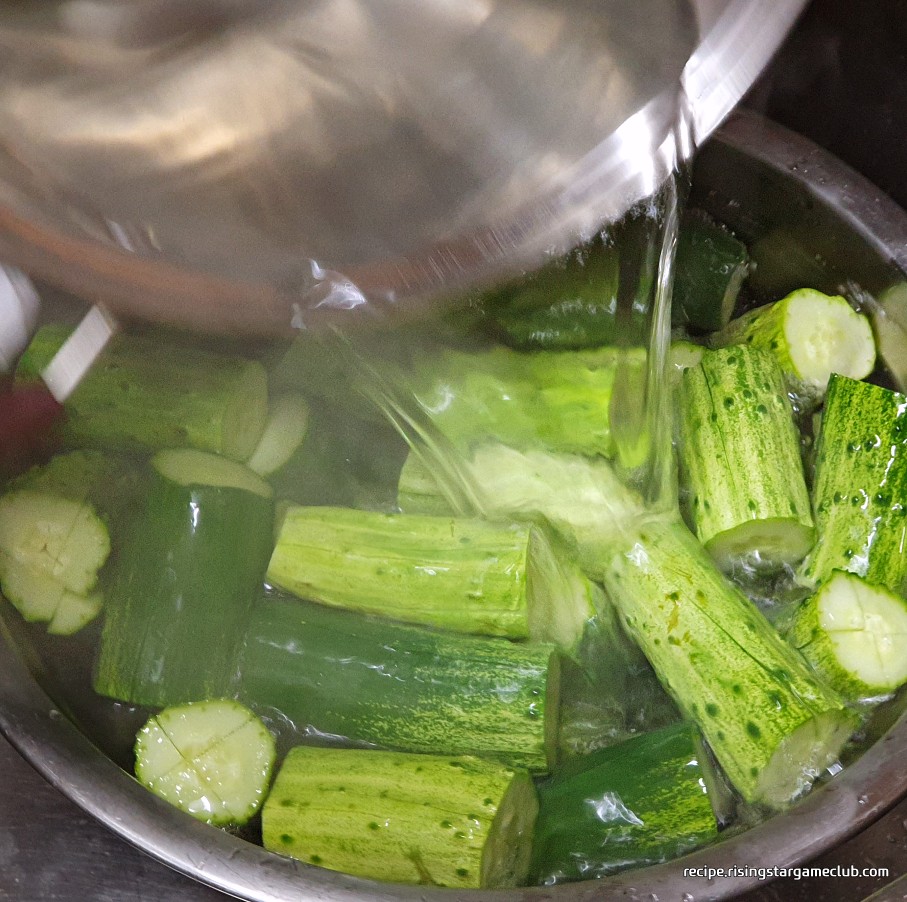 오이 소박이에 들어갈 오이를 절이기 위해 끓는 소금물을 오이에 붓는 사진