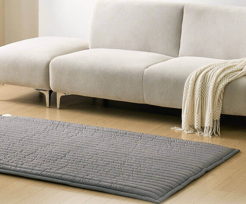 소파 옆에 깔아놓은 회색 전기매트