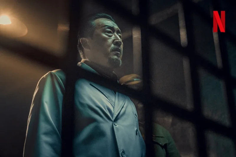 의사 가운을 입고 서 있는 경성크리처에서 이치로 역을 연기하는 배우 현봉식