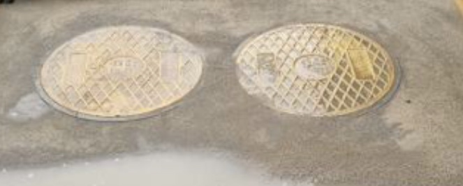 노란색 원형의 맨홀 뚜껑의 모습