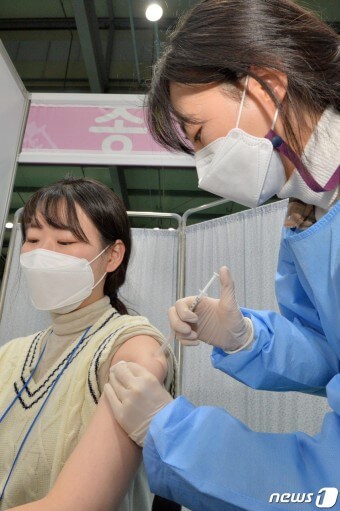 푸른-방호복을-입은-간호사가-코로나-접종을-해주는-모습