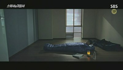 거실에서 침낭 속에서 잠을 자려고 하는 김래원 사진입니다.