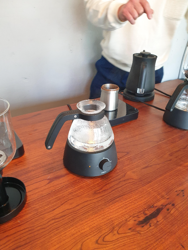 큰 우드 테이블 위에 여러대의 사이폰과 그라인더 그리고 드립포트가 놓여 있다.