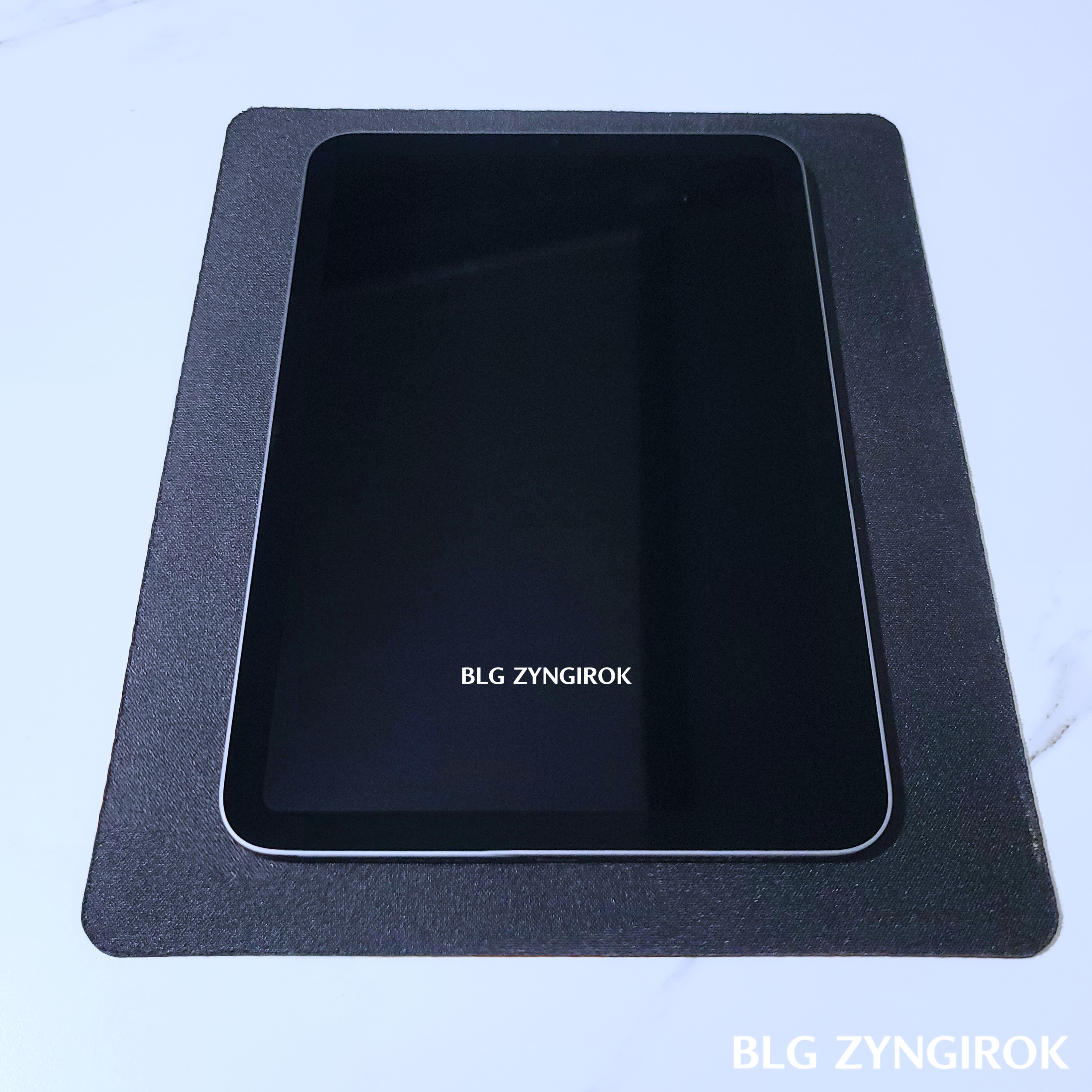 아이패드 미니가 꺼진 상태로 테이블 위에 놓여있다.