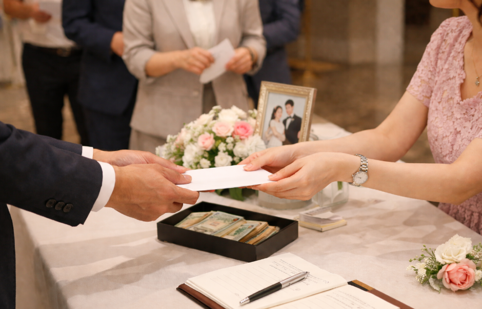 결혼식장에서 축의금 봉투를 준비하는 하객의 자연스러운 모습