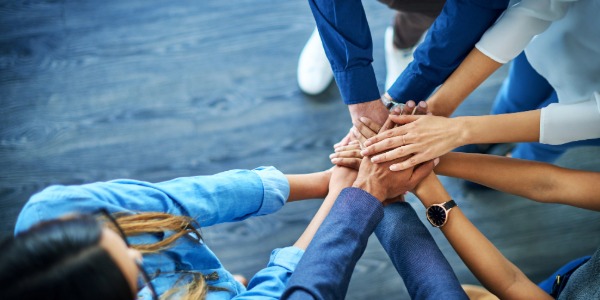 여러 사람이 손을 한데 모아 팀워크를 다지는 모습
