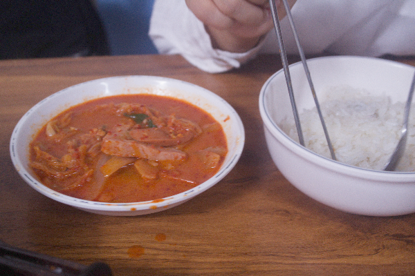 플라스틱 공기(대접)에 나온 밥과 한 국자 뜬 부대찌개