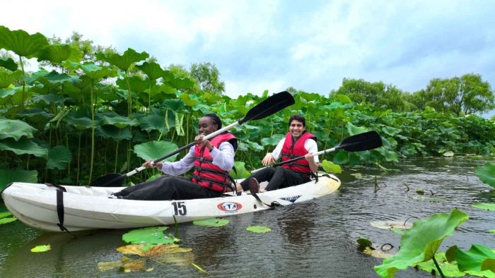 연꽃이 가득한 궁남지 수로에서 카약을 타며 연꽃 탐험을 즐기는 외국인 관광객