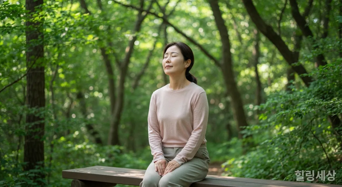 숲 속 벤치에 앉아 눈을 감고 명상하는 한국인 여성