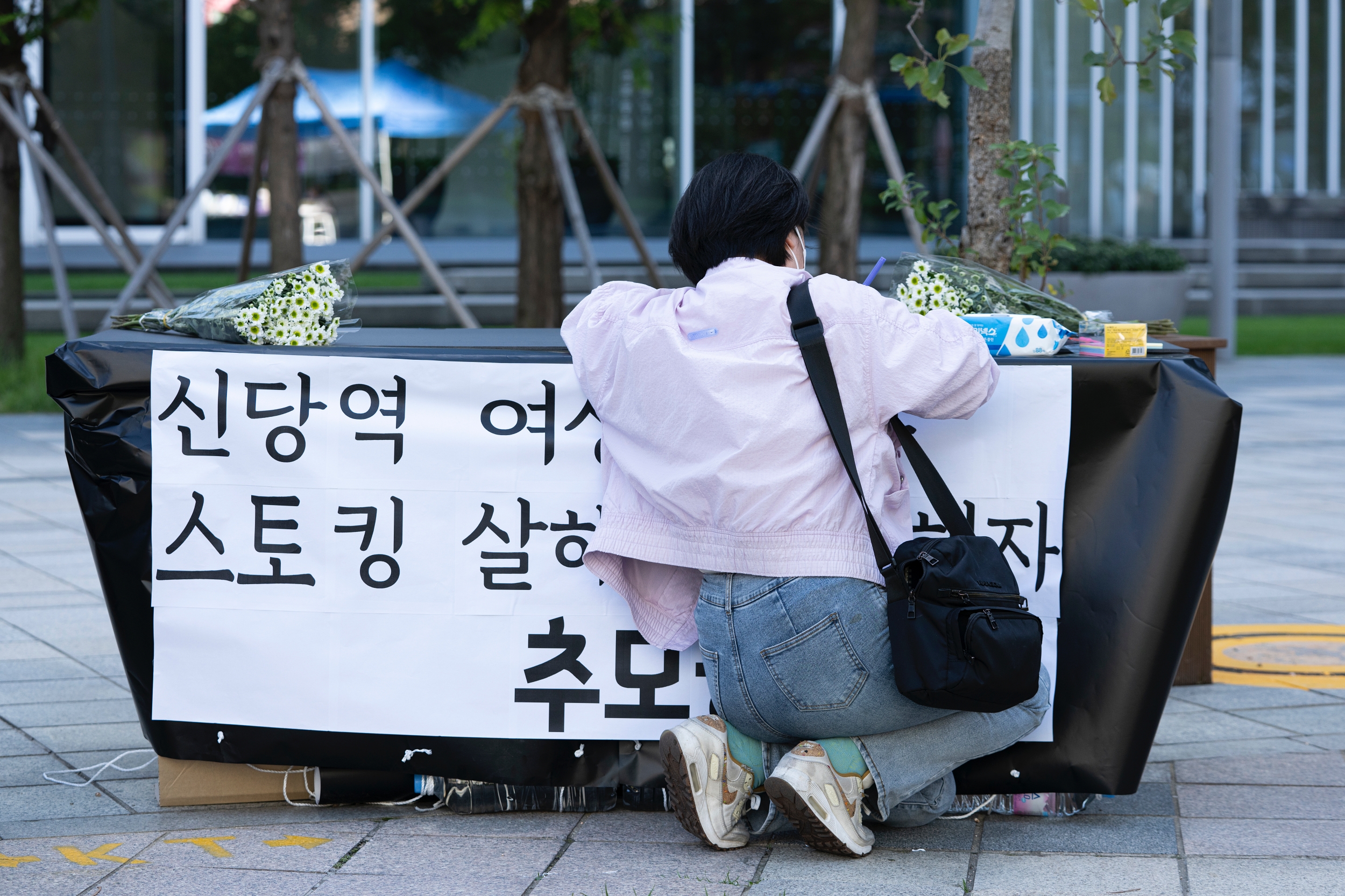 시민이 신당역 스토킹 살해사건 추모 부스에서 메시지를 적고 있다.