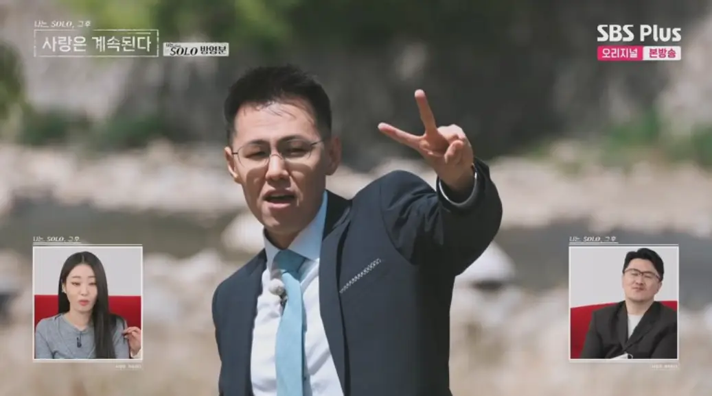 나솔사계-
파란색 정장을 입고 손으로 V자를 그리며 말하고 있는 안경쓴 스포츠 머리의 남자