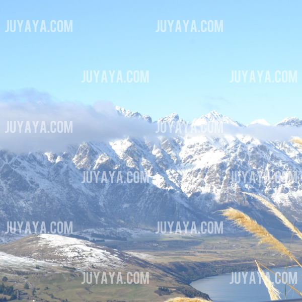 뉴질랜드 퀸스타운의 눈 덮인 산맥과 푸른 하늘이 펼쳐진 모습.