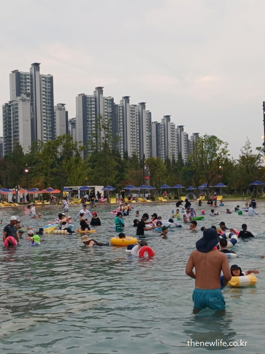 잠실 한강공원 물놀이장에서 가족 단위로 튜브를 타고 물놀이를 즐기고 있는 시민들 모습 – 수심이 얕은 물놀이장 전경