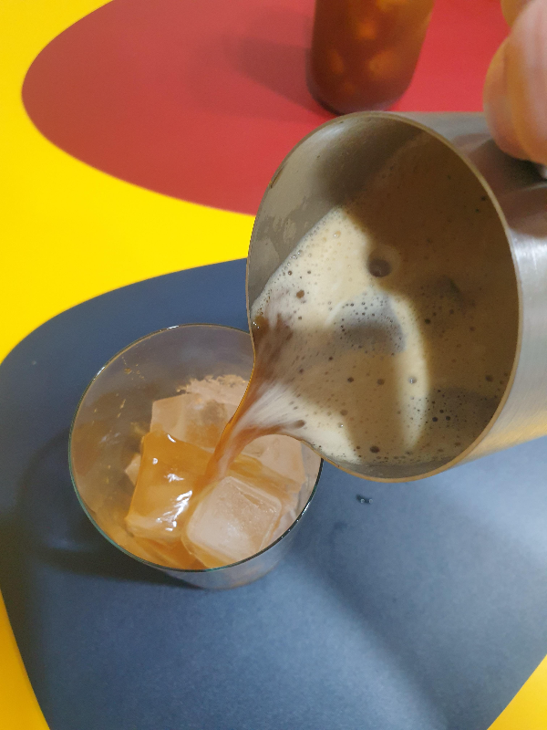 거품이 올라온 커피를 얼음이 담긴 유리컵에 넣는다.